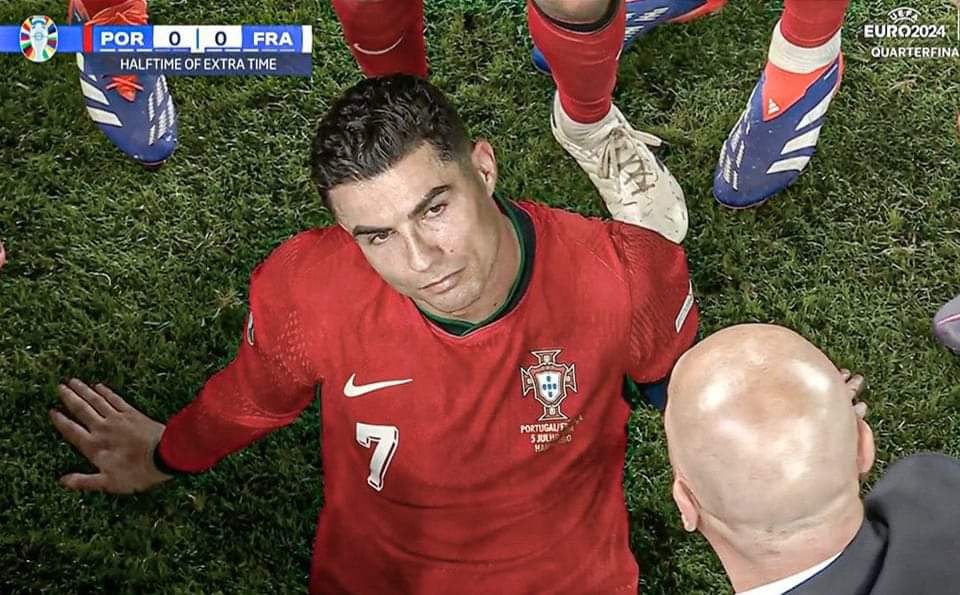 Captura da transmissão televisiva do Euro2024, num momento em que o selecionador nacional fala aos atletas. Cristiano Ronaldo surge sentado no meio de uma roda formada pelos seus colegas.